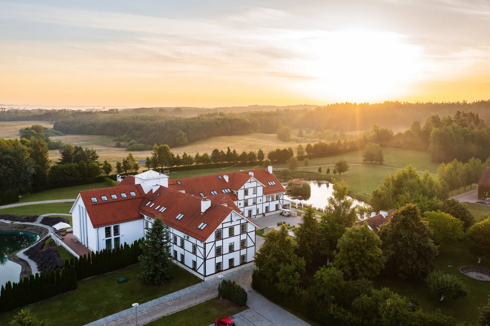 Hotel nad jeziorem o wschodzie słońca z drona — fotografia hoteli, Warmia i Mazury